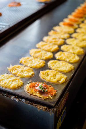 Fresh prepared golden sweet crepes khanom buang on local market in Bangkok. Traditional thai cuisine...