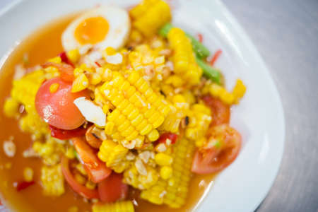 Fresh prepared asian spicy som tam corn salad with vegetables on local market in Bangkok....