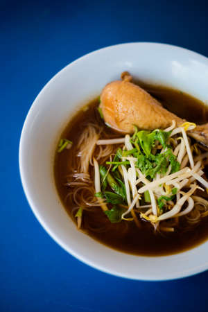Fresh prepared asian aromatic dark soy sauce broth steamed meat soup with rice noodles in local...