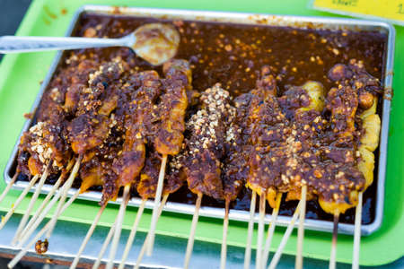 Fresh asian spicy satay chicken skewers barbeque on local market in Krabi town. Traditional thai...
