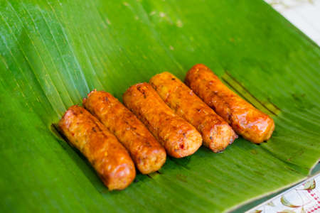 Fresh asian spicy isan pork sausages barbeque on banana leaf on local market in Krabi town. Traditional thai cuisine made of fresh ingredients.の写真素材