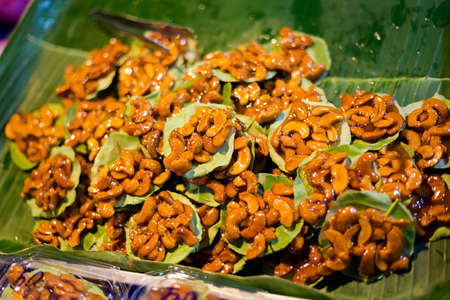 Fresh prepared cashew nuts cakes on banana leaf on local market in Krabi. Traditional thai cuisine made of fresh ingredients.の写真素材