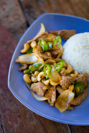 Fresh prepared asian spicy cashew nut pork, onion and pepper stirfry served with jasmine rice in local restaurant on Koh Kradan island. Traditional thai cuisine made of fresh ingredients.の写真素材