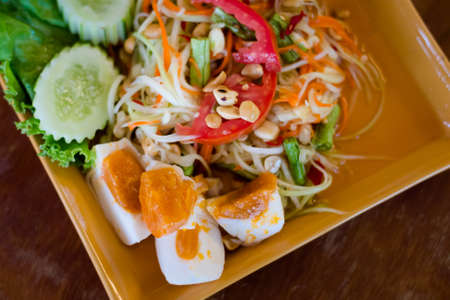 Fresh prepared asian spicy Som Tam papaya salad served with salted eggs in local restaurant on Koh Lanta island. Traditional thai cuisine made of fresh ingredients.の写真素材