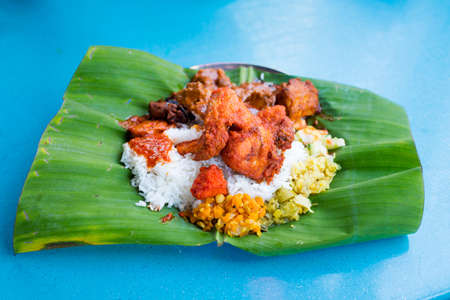 Fresh prepared selection of malaysian local indian food served on banana leaf in restaurant in Kuala Lumpur. Traditional asian cuisine made of fresh ingredients.の写真素材
