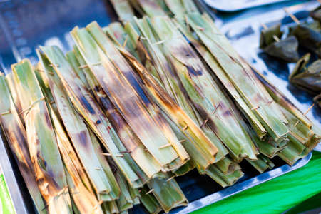 Fresh prepared malaysian barbeque in banana leaf on local market on Langkawi island. Traditional asian cuisine made of fresh ingredients.の写真素材