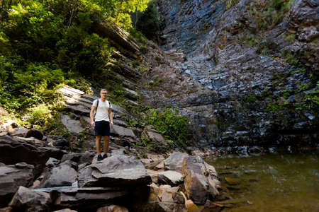 Young tourist on Temurun waterfall on tropical Langkawi island in Malaysia. Beautiful nature of...