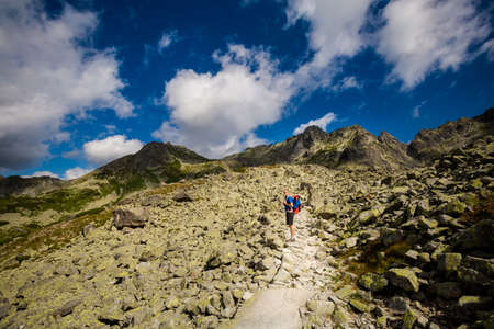 Tourist on the way to Rysy highest peak of Poland.  Path from Slovakia, Strbske, Popradske pleso, Zabie Ridge, frog's lakes valley and Chata pod Rysmi chalet. Summer panoramaの写真素材