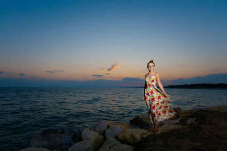 Summer landscape with young caucasian woman watching golden sunset on tropical beach in Side, Turkey. Holiday photos taken in paradise scene during honeymoon.の写真素材