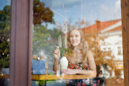 Young caucasian woman in Valasske Mezirici taken during sunny weather. Poirtrait with ice coffee captured during holiday.の写真素材