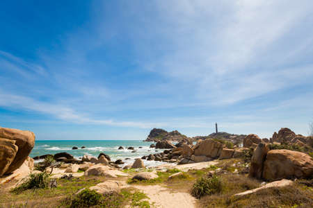 Summer seascape with Ke Ga Lighthouse in Vietnam. Landscape taken from the beach with blue sky on...