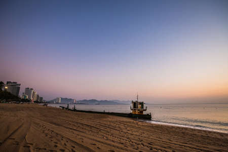 Old boat on a beach during beautiful golden sunrise in Nha Trang, Khanh Hoa province in Vietnam.の写真素材
