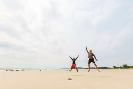 Happy tourist couple on Son Hao beach, Quan Lan island, Bai Tu Long Bay, Vietnam. Seaside scenery photo taken in south east Asia, Ha Long area.の写真素材
