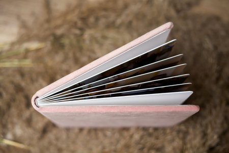 Closeup of opened exclusive photobook covered with velvet textile. Wedding photo album detail Education concep with book pagesの写真素材