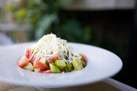 Delicious colorful vegetarian local food shopska salad with cheese in a restaurant, Sozopol. Traditional bulgarian cuisine in Bulgaria.の写真素材