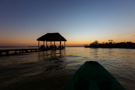 Group of people watching beautiful sunrise in Laguna Bacalar in Mexico. Photo taken during a kayak trip.の写真素材