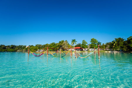Beautiful white female tourist relaxing in a hammock in Laguna Bacalar in Mexico during kayak trip.の写真素材
