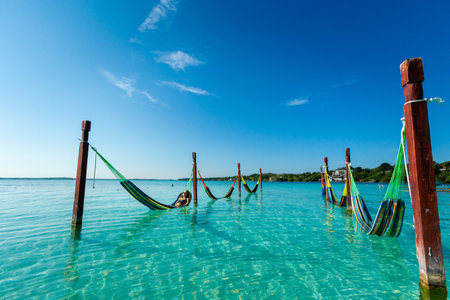 Beautiful white female tourist relaxing in a hammock in Laguna Bacalar in Mexico during kayak trip.の写真素材