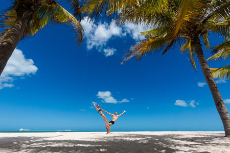 Beautiful young happy couple in Progreso beach, Mexico during a sunny day. White beach and blue sky.の写真素材