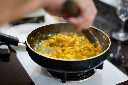 Traditional way of preparing indian food mushroom curry using gas pan. Picture of traditional India cuisine made of fresh ingredients taken during cooking class in Goaの写真素材