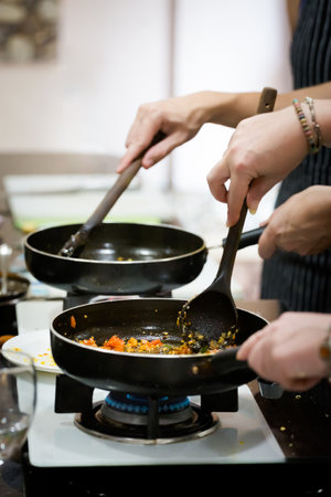 Traditional way of preparing indian food aloo gobi (potatoes with cauliflower) using gas pan. Picture of traditional India cuisine made of fresh ingredients taken during cooking class in Goaの写真素材