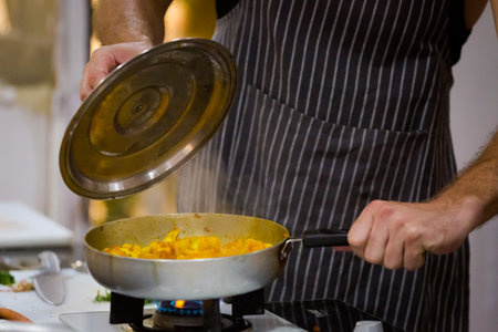 Traditional way of preparing indian food aloo gobi (potatoes with cauliflower) using gas pan....