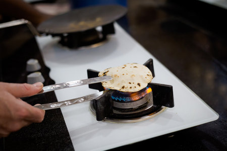 Traditional way of preparing indian food, making roti bread. Picture of traditional India cuisine made of fresh ingredients taken during cooking class in Goa.の写真素材