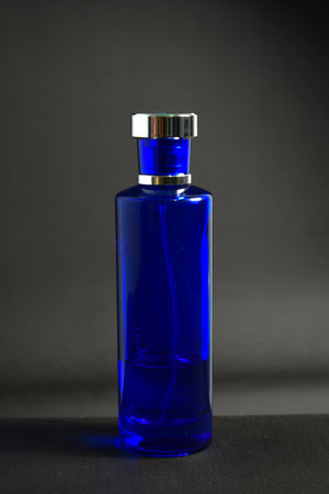 Transparent Dark Blue Bottle Perfume isolated black background for mock up designの写真素材