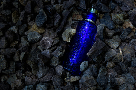 Transparent blue bottle in gravel backgroundの写真素材