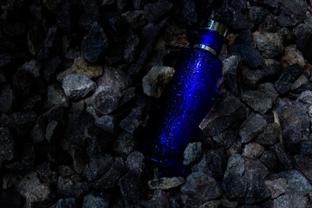 Transparent bottle in gravel or coral background