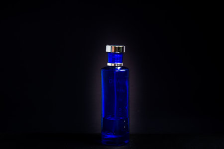 Transparent Dark Blue Bottle Perfume isolated black background for mock up designの写真素材