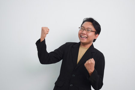 Happy asian businessman shout loud yeah with hands rise up isolated white backgroundの写真素材