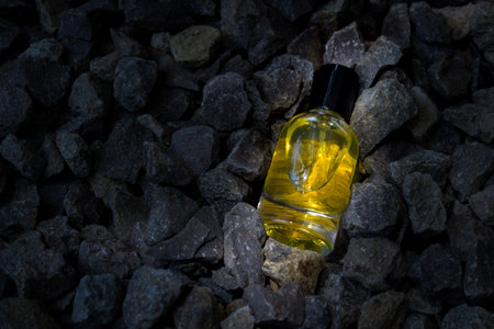 Perfume Yellow transparent bottle in gravel or coral backgroundの写真素材