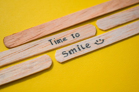 stick of ice cream with the words time to smile. Motivational quotes, optimism, positive words. Isolated on backgroundの写真素材