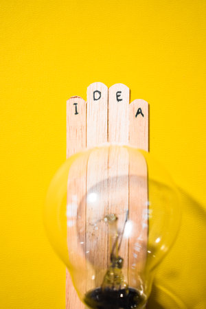 Wooden sticks with the words Idea and a lightbulb. Motivational quotes, optimism, positive words. Isolated on backgroundの写真素材