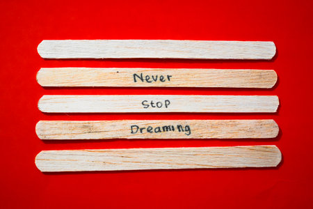 stick of ice cream with the words Never Stop Dreaming. Motivational quotes, optimism, positive words. Isolated on backgroundの写真素材