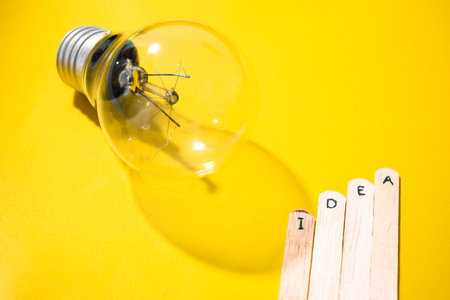 stick with the words Idea and lightbulb. Motivational quotes, optimism, positive words. Isolated on backgroundの写真素材
