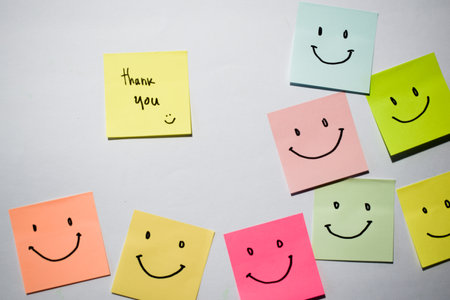 Thank you and smile emoticon on sticky notes. Motivational for personal development, inspirational handwriting. Isolated on backgroundの写真素材