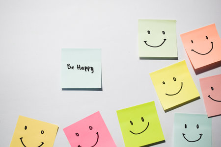 Be Happy and smile emoticon on sticky notes. Motivational words for personal development, inspirational handwriting. Isolated on backgroundの写真素材