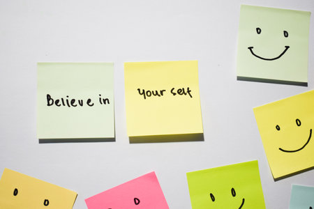 Believe in yourself and smile emoticon on sticky notes. Motivational words for personal development,...