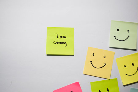 I am strong and smile emoticon on sticky notes. Motivational words for personal development, inspirational handwriting. Isolated on backgroundの写真素材