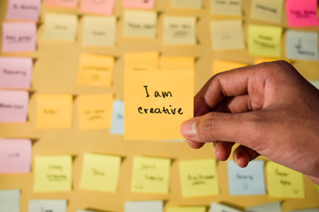 Hand hold sticky notes with words I am creative. Motivational words for personal development, inspirational handwriting. Sticky notes backgroundの写真素材