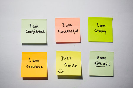 I am confident, I am strong, never give up with smile emoticon on sticky notes. Motivational for personal development, inspirational handwriting. Isolated backgroundの写真素材