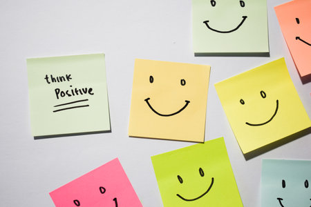 Think Positive and smile emoticon on sticky notes. Motivational words for personal development, inspirational handwriting. Isolated on backgroundの写真素材