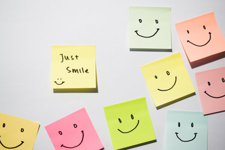 Just Smile and smile emoticon on sticky notes. Motivational words for personal development, inspirational handwriting. Isolated on backgroundの写真素材