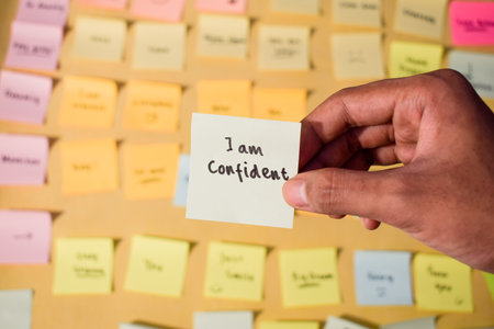 Hand hold sticky notes with words I am confident. Motivational words for personal development, inspirational handwriting. Sticky notes backgroundの写真素材