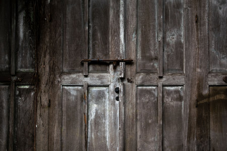 Big old broken wooden door on brick wall of historical building located in Kota Lama, Semarang City, Indonesia.の写真素材
