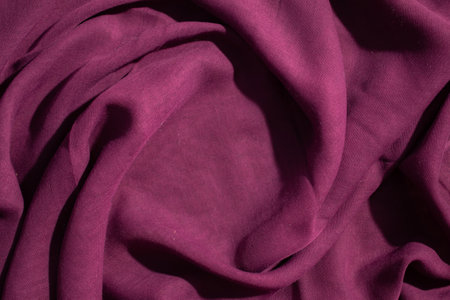 Soft purple fabric wavy spiral crumpled background texture with copy space in the center.の写真素材