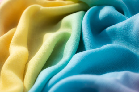 Close up Gradient yellow blue pink and green fabric wavy crumpled background texture.の写真素材