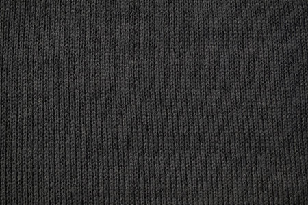 Detailed dark grey knitted fabric background texture.